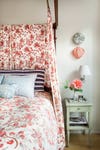 bed cloacked in red floral fabric