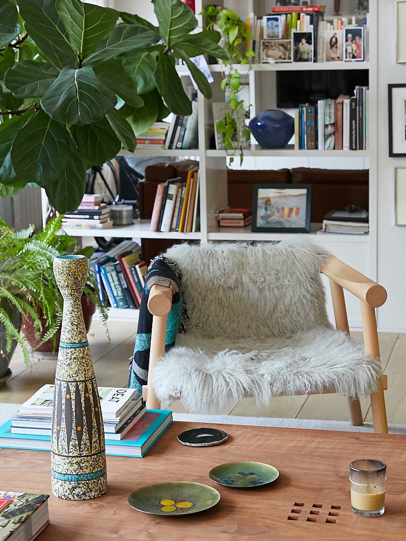 eclectic living room with a wood chair with a sheepskin throw on it