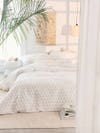 White bedspread on a mattress on the floor