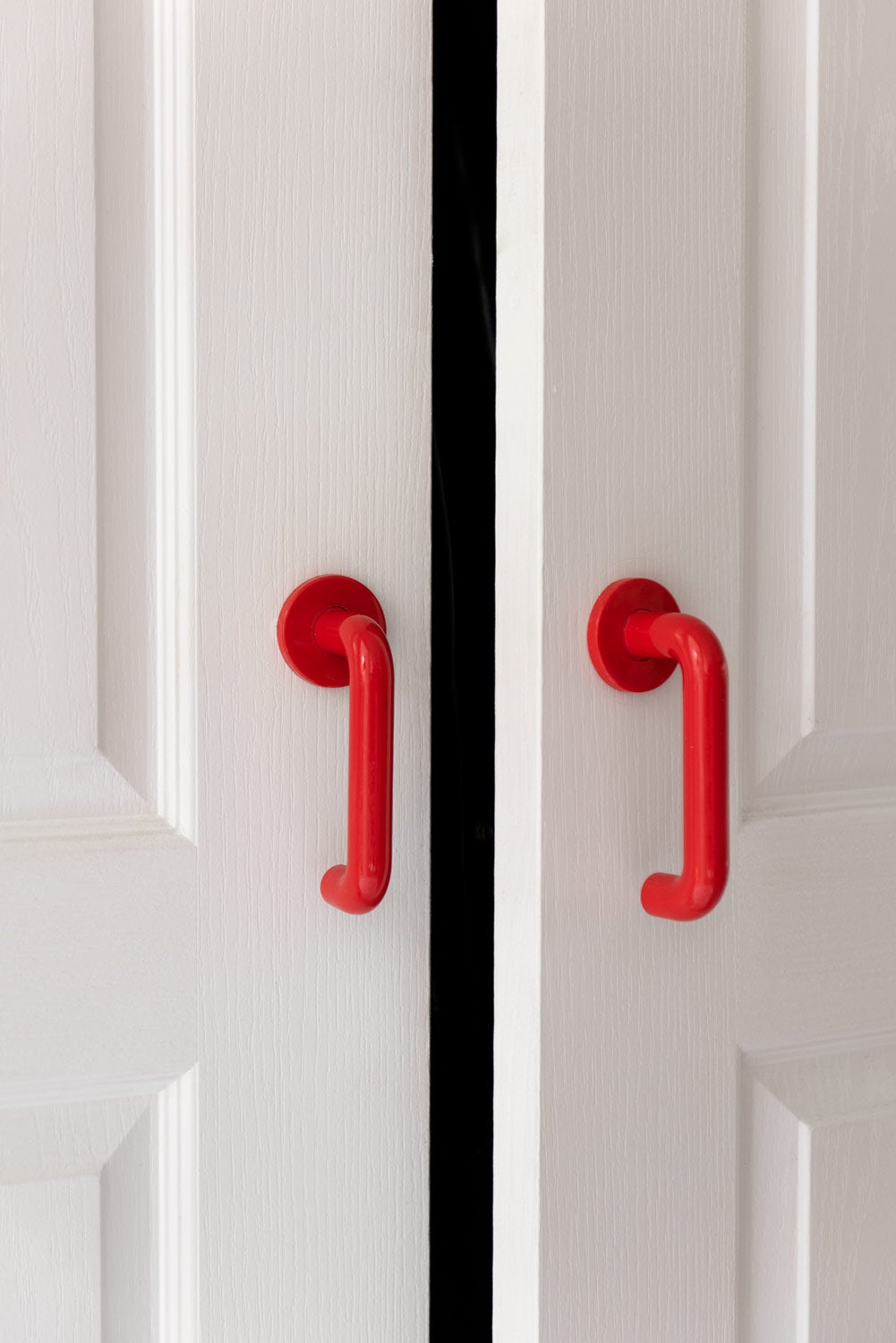 Red door handles on white door