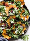 Salad with acorn squash slices, goat cheese dressing, and pomegranate seeds.