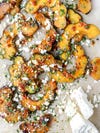 Slices of acorn squash topped with feta and herbs.