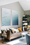 large scale prints of water above living room sofa