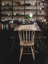Dining table and chair in a room with a wooden floor painted black