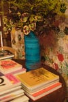 plant in blue vase next to stacks of books