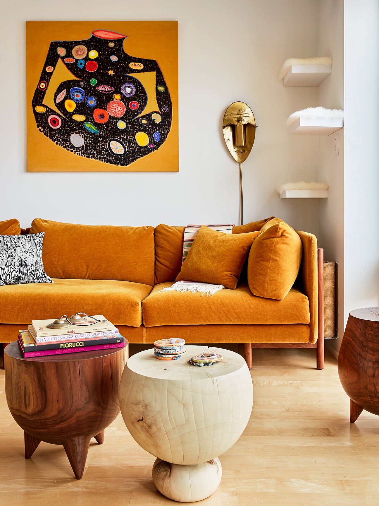 Living room with orange sofa and art.