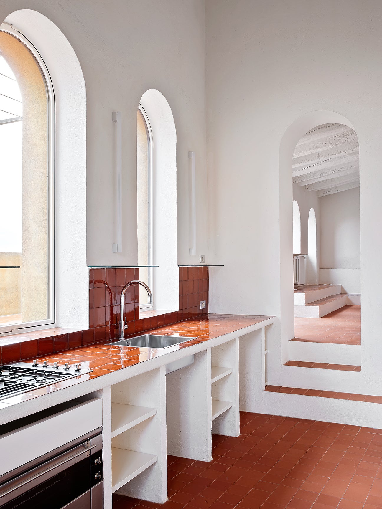 White kitchen with terra cotta floors and countertops