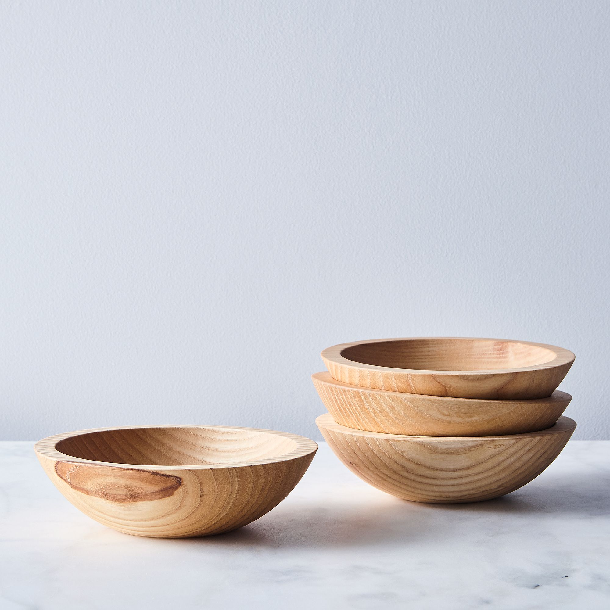 four wood bowls on a light background