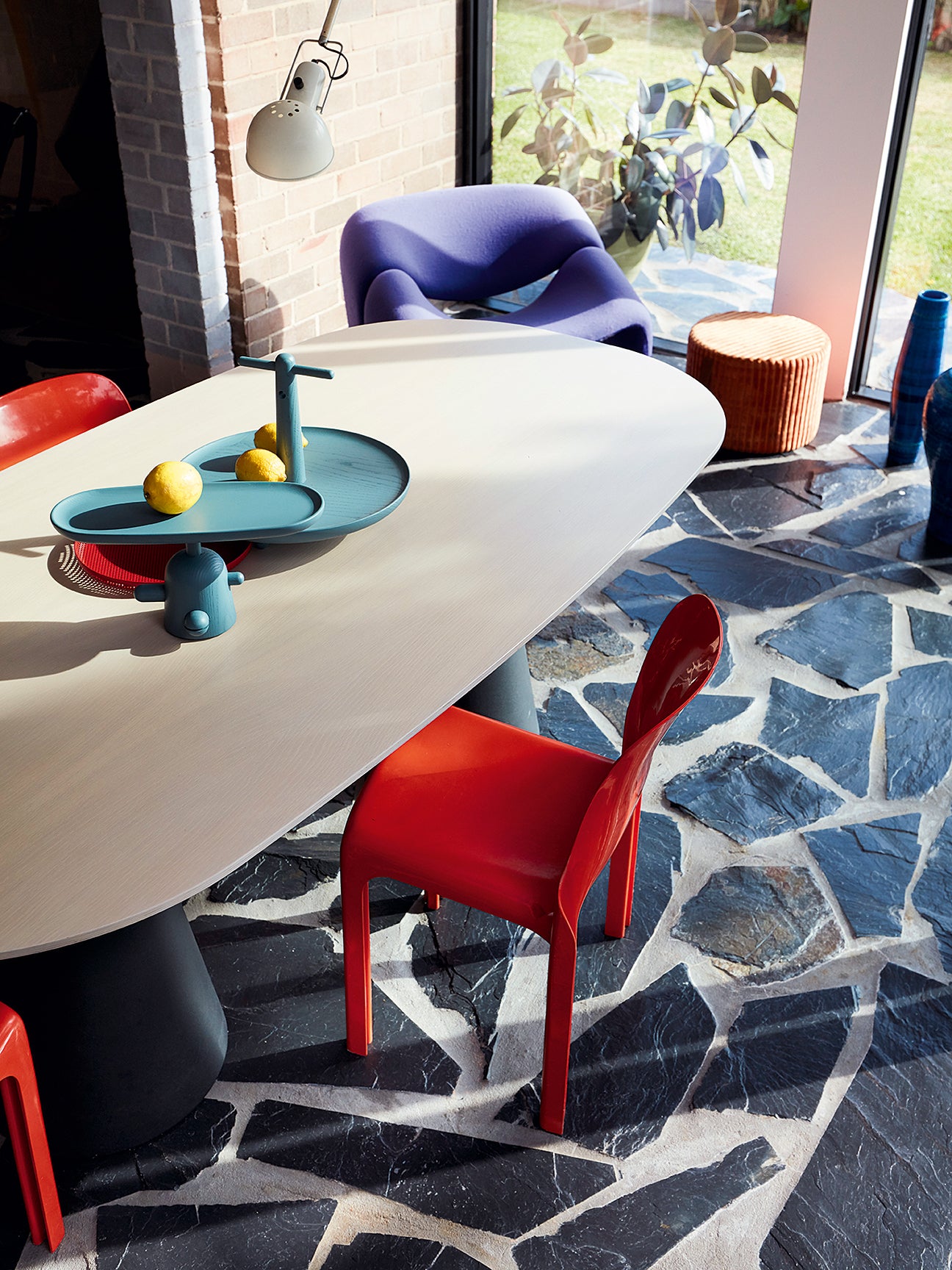 Dark terrazzo floors with red dining chairs