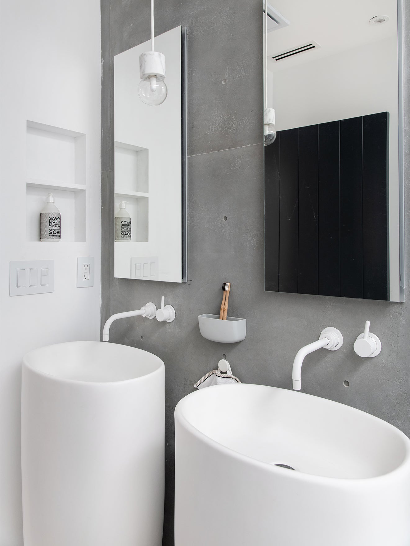 white column pedestal sinks in gray bathroom