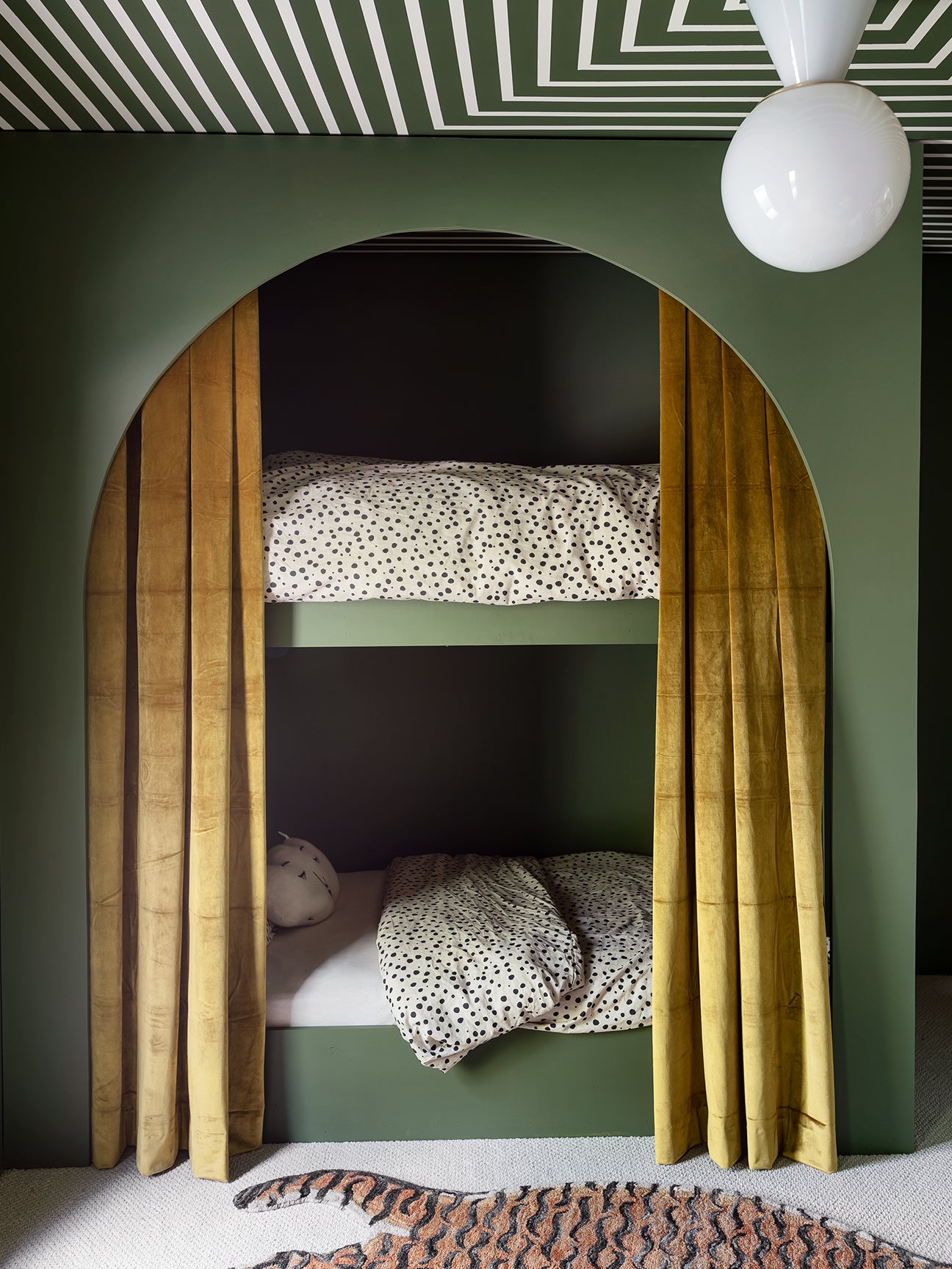 Green bunk beds with velvet curtains