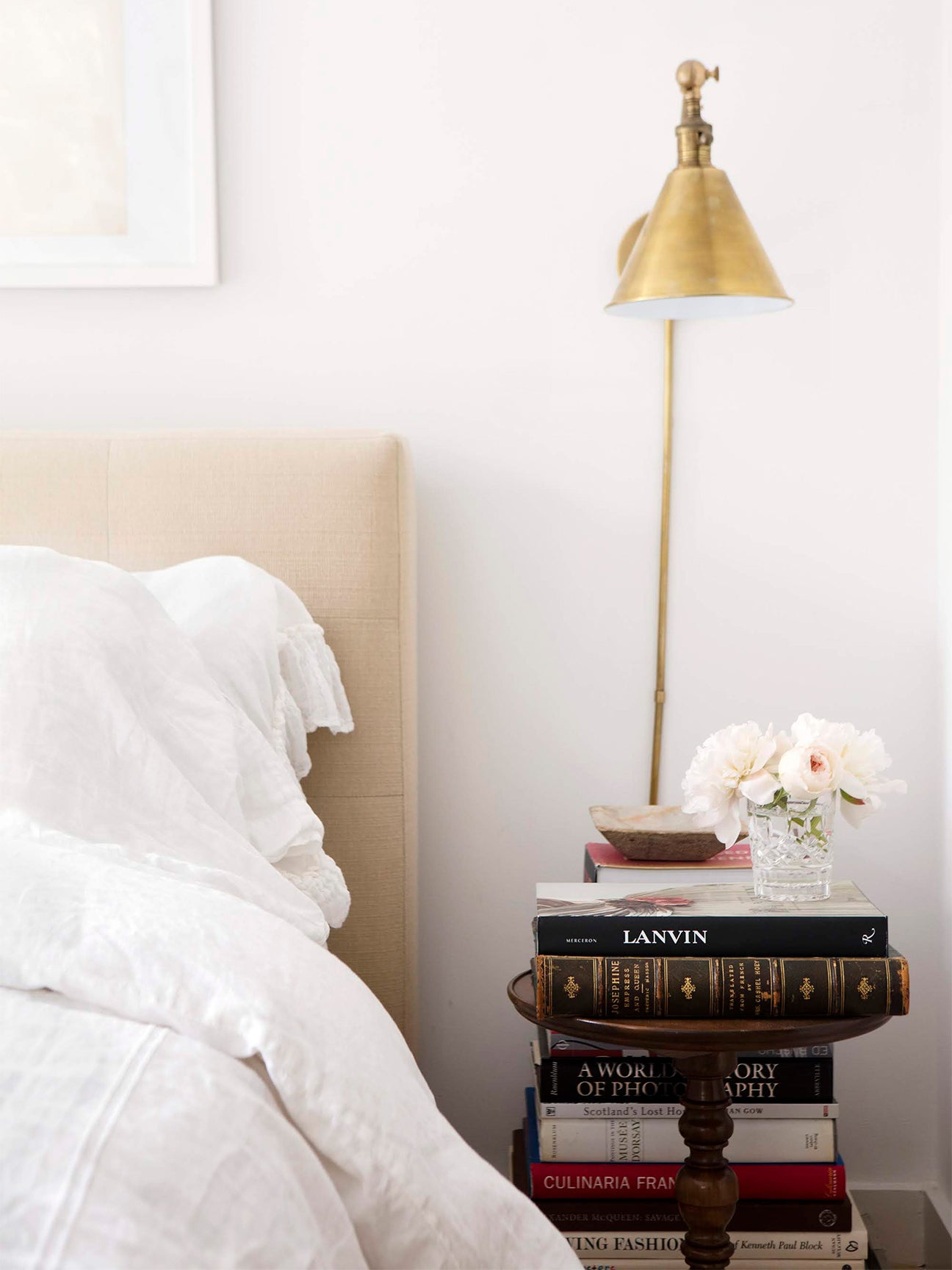 Bed and bedside table with pile of books