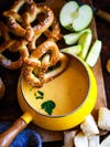 pretzels falling into cheese fondue