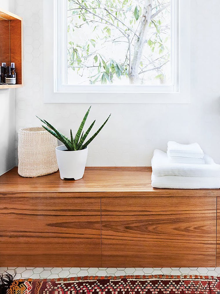 wood bench in a bathroom with aloe plant
