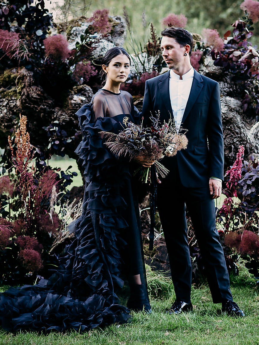 Lydia Pang and Roo Williams in front of a gothic floral display