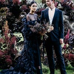 Lydia Pang and Roo Williams in front of a gothic floral display