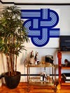 Brass bar cart with tall plant and '70s blue and white artwork