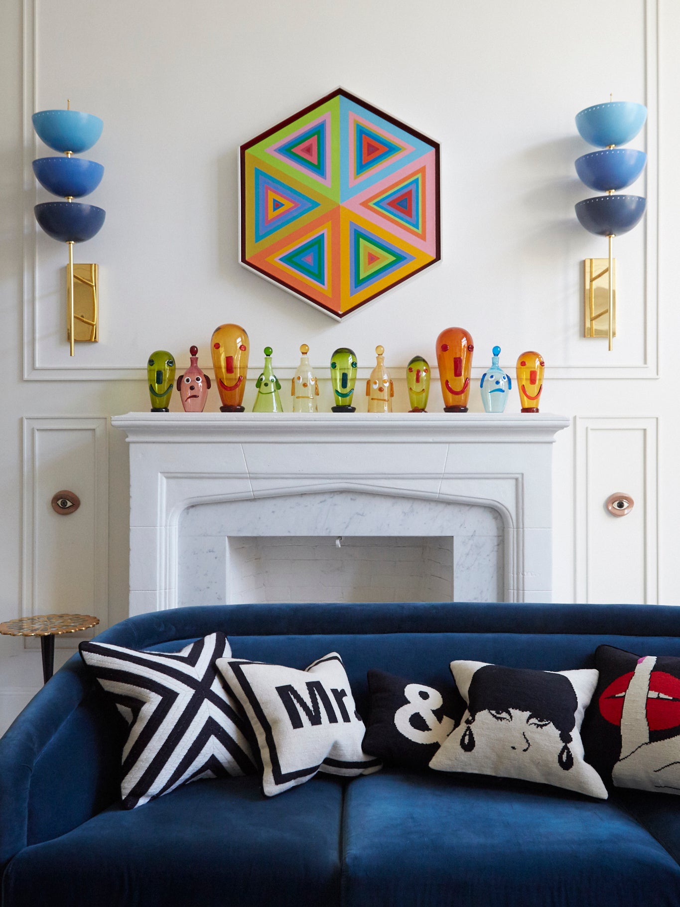 colorful mantel with glass figurines in front of blue sofa