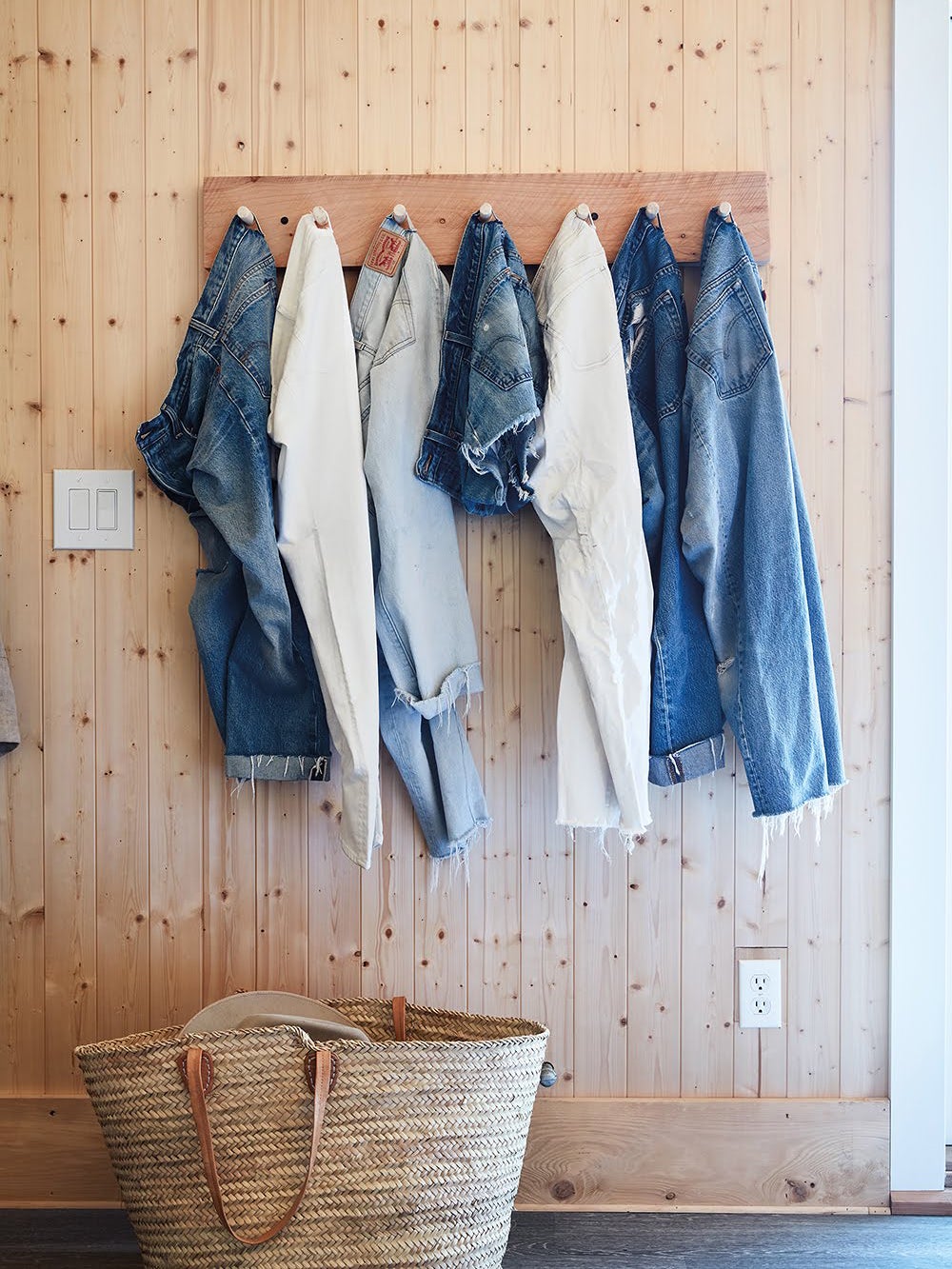 pairs of jeans hanging from a wall