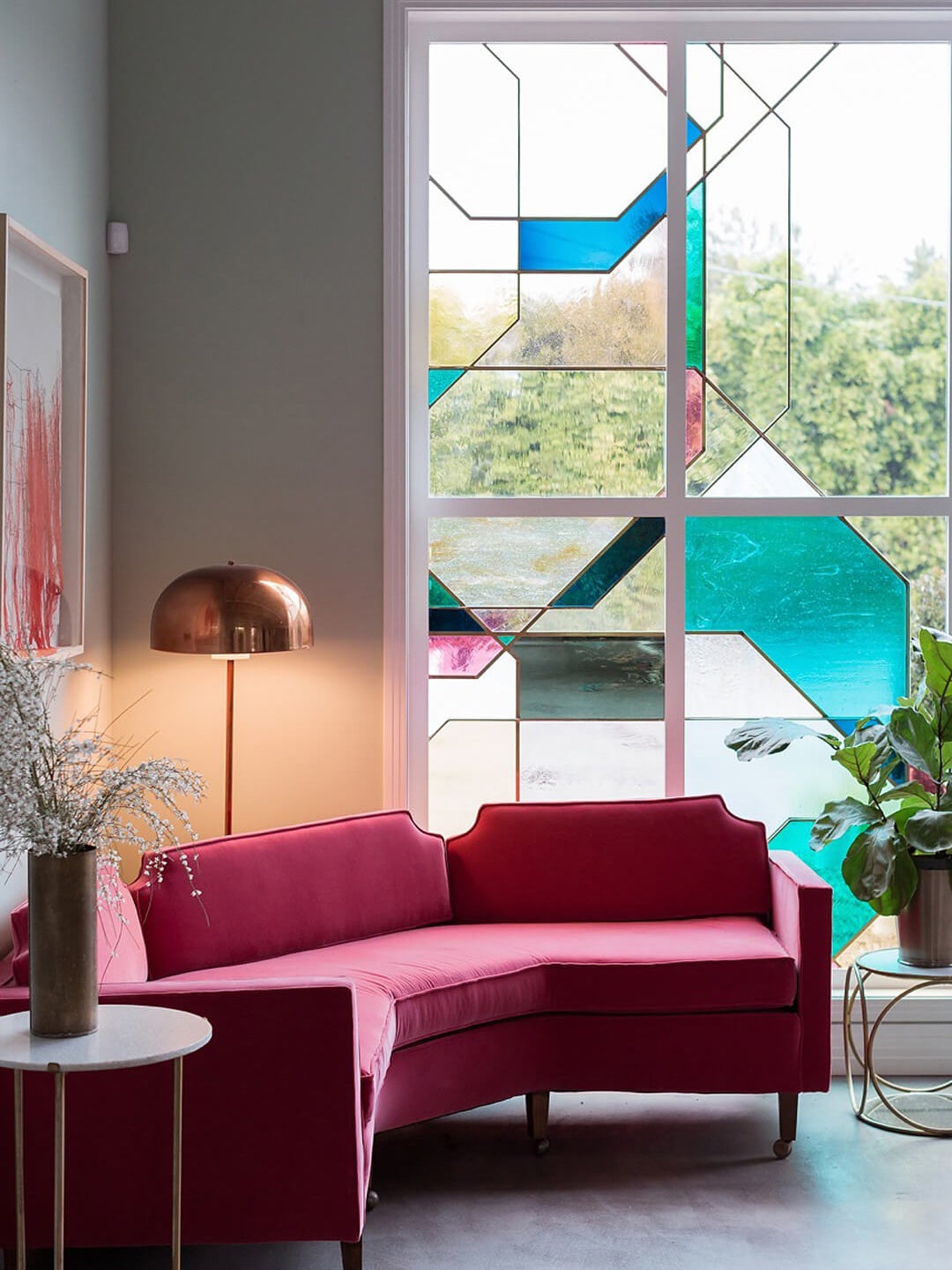pink sofa in front of stained glass window
