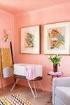 pink nursery with white and wood bassinet