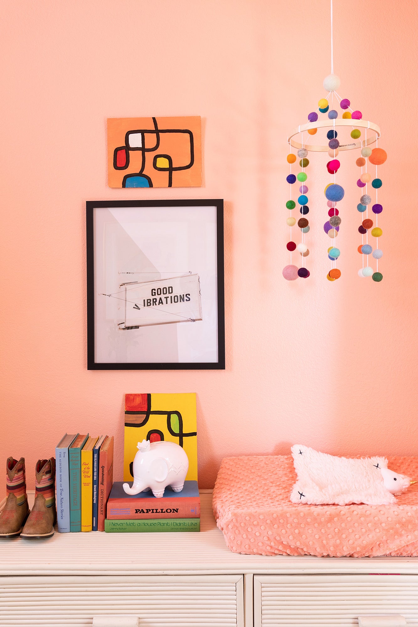 pom pom mobile over a pink changing table