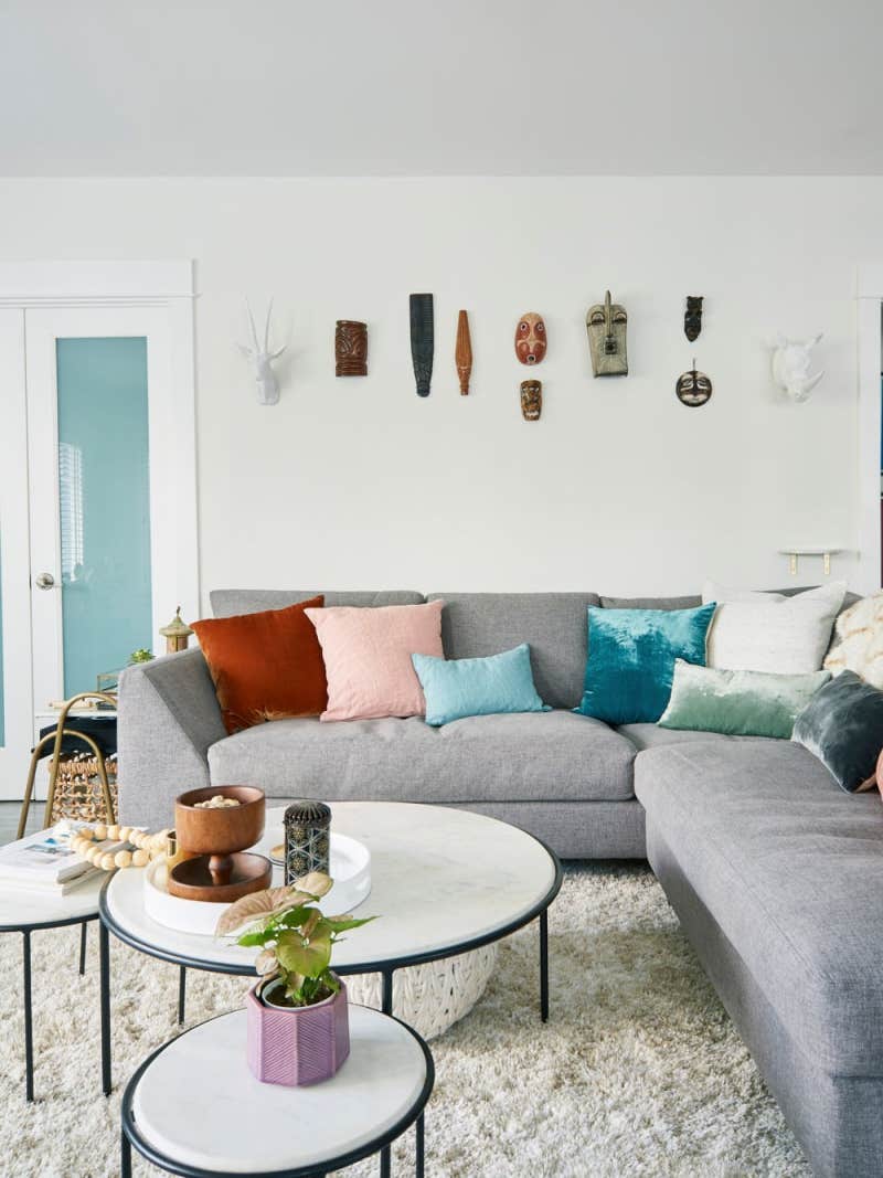 white living room with grey sofa and colorful throw pillows