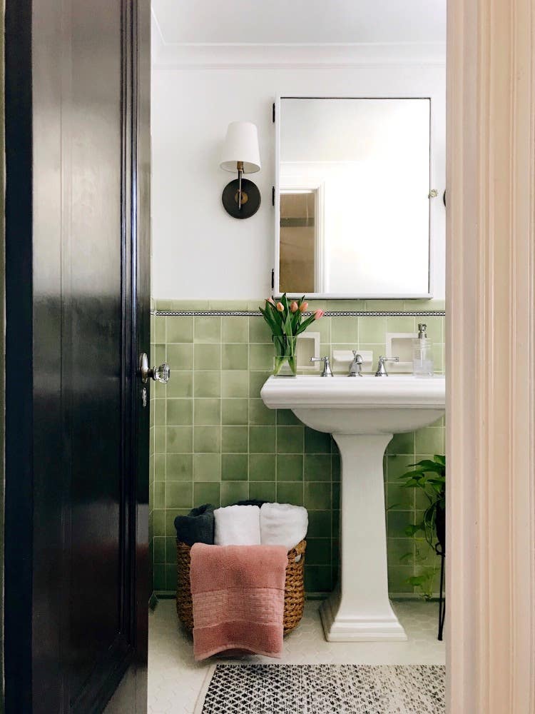 green wall tile and white floors in a bathroom