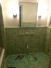 green tile bathroom without a sink or toilet