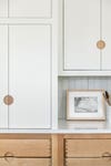 white cabinets with wood cut outs for handles