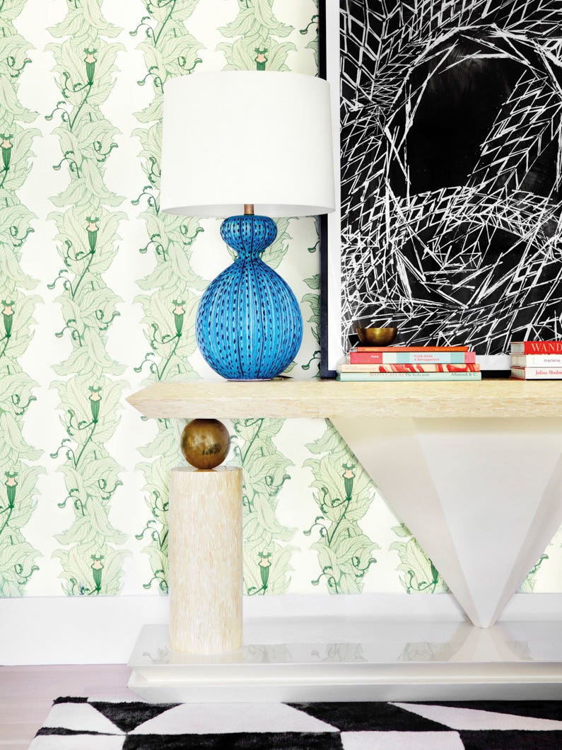 entryway with console table and green leaf wallpaper
