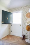 entryway with dutch door and floral wallpaper