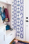 Entryway with blue and white graphic wallpaper and white closet