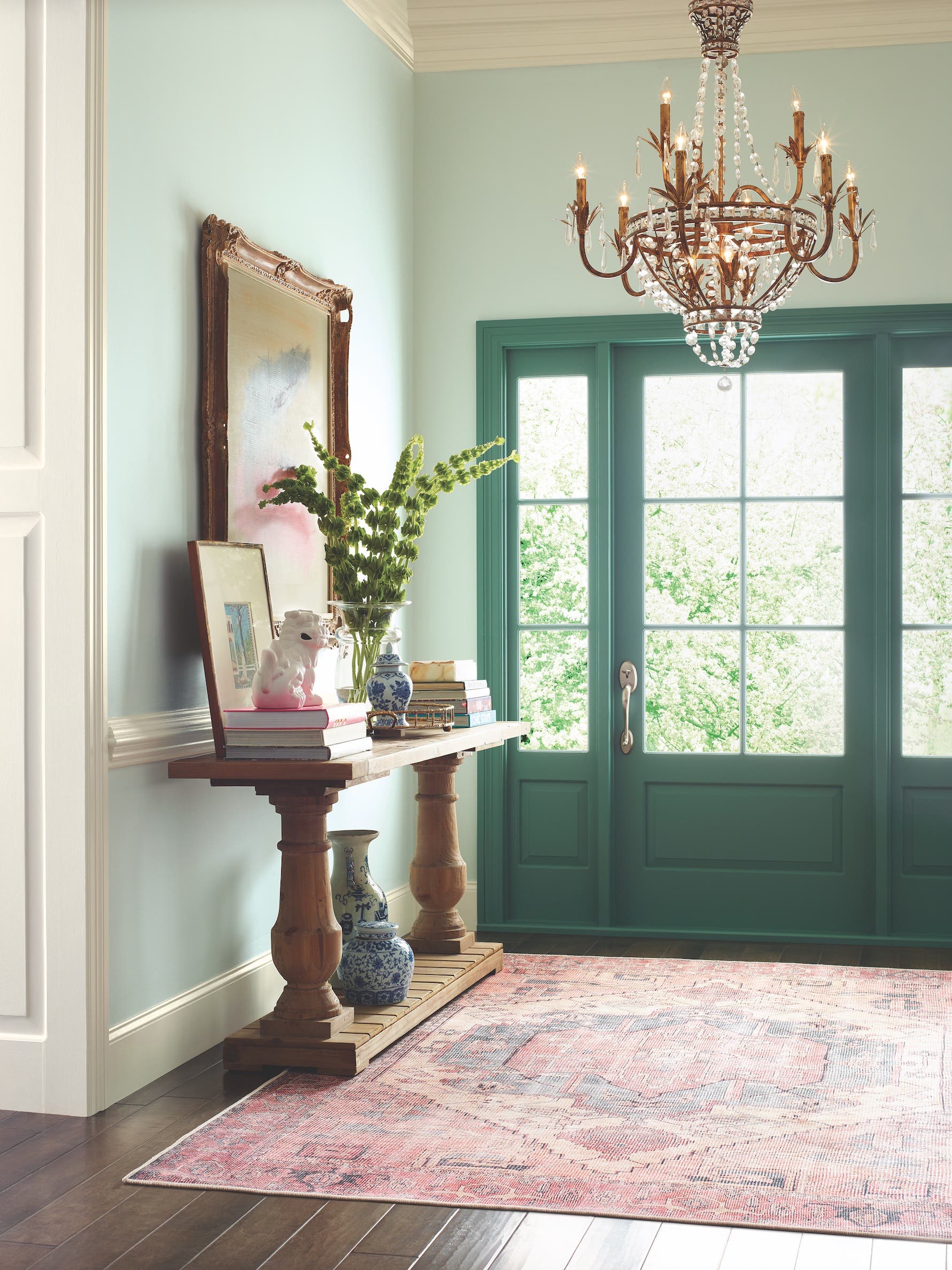 green entryway with chandelier