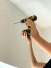 person drilling holes in wall