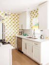 white galley kitchen with lemon wallpaper