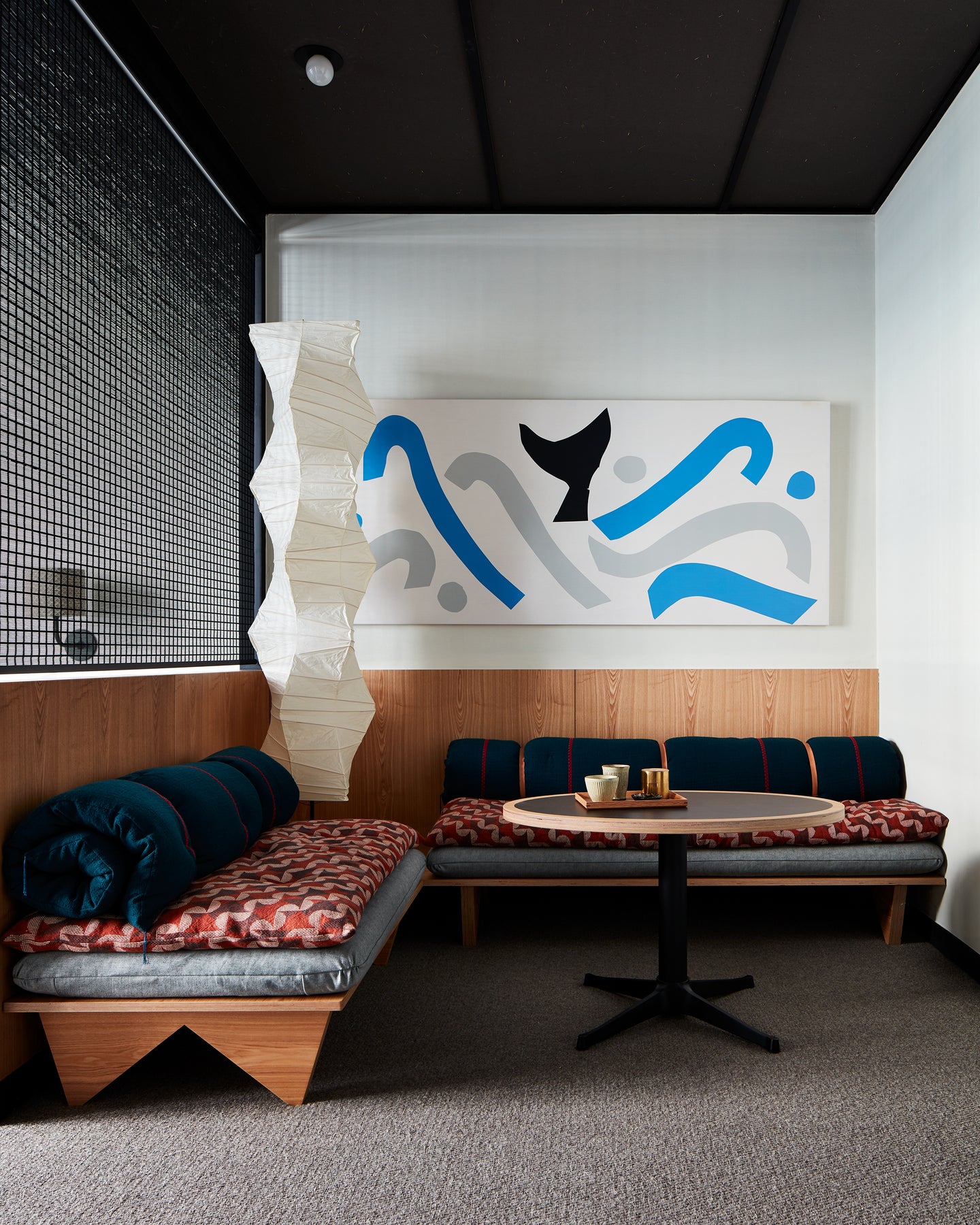 two couches in a corner with large abstract art on wall