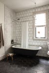 tiled bathroom with claw foot tub