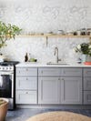 light gray cabients and bold wallpaper