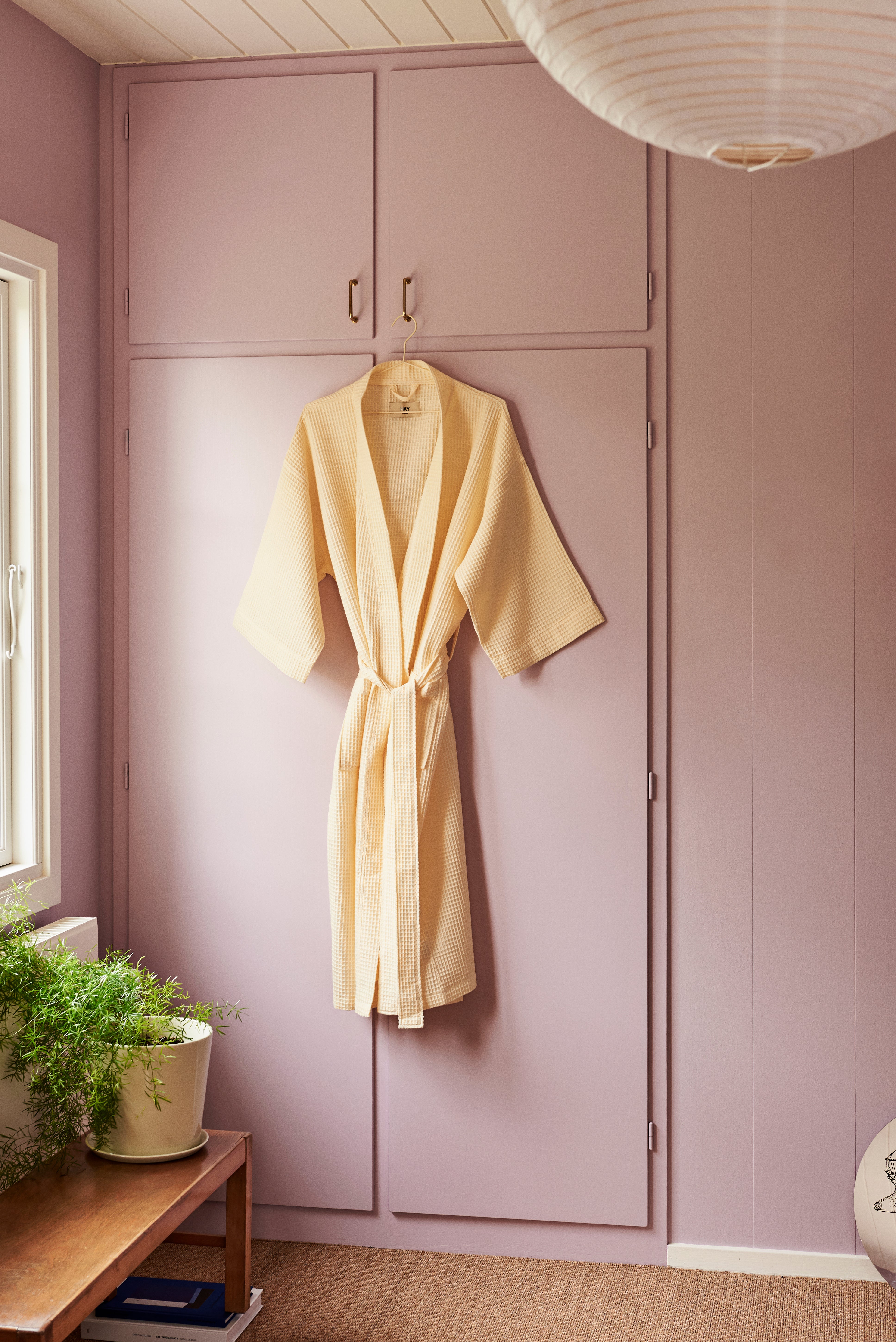 pink closet with yellow bathrobe hanging