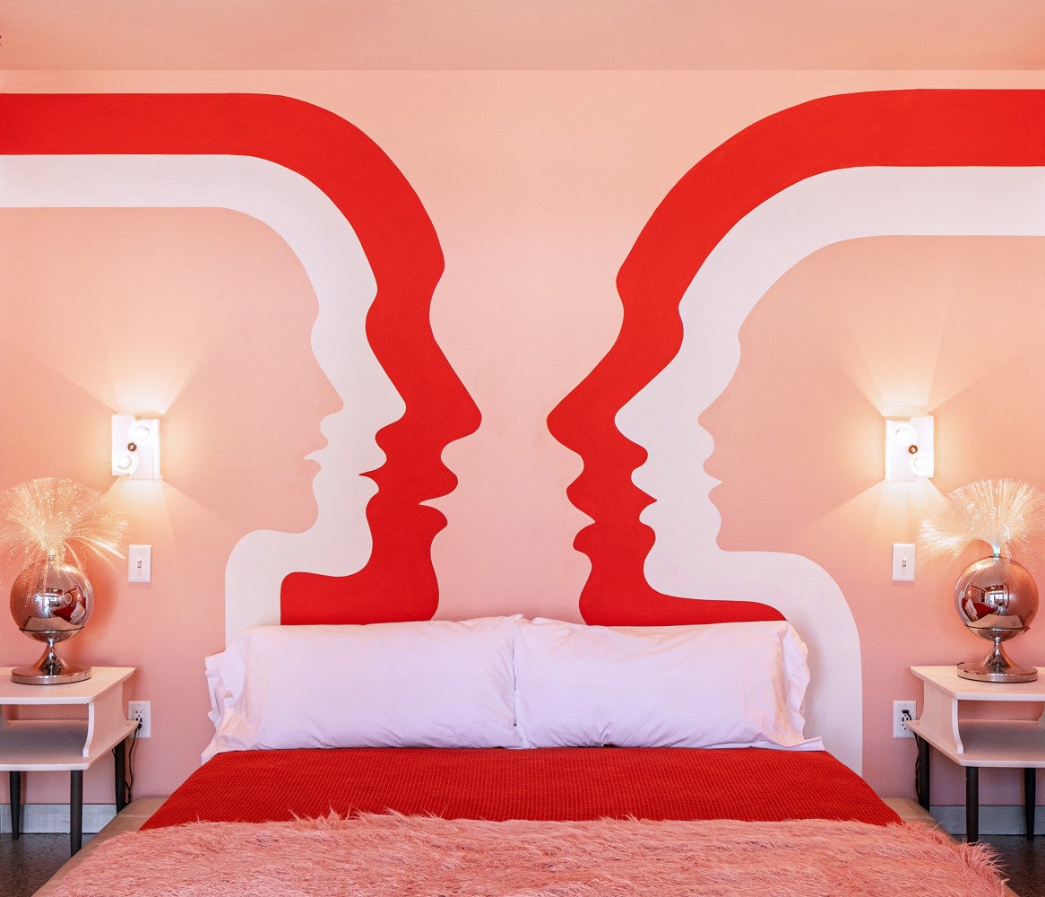 pink and red face mural on wall