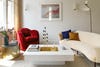 living room with white coffee table red chair and white sofa