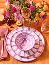 purple ceramic plate on table with floral arrangement