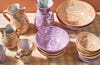 peach and lilac pottery on checkered tablecloth