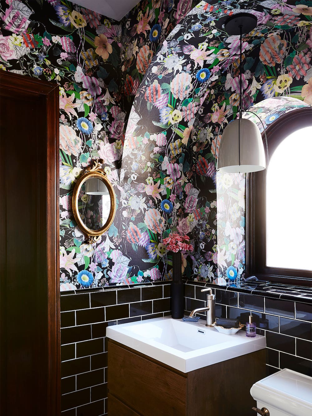 arched bathroom with black floral wallpaper
