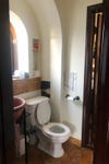 dated bathroom with arch over toilet