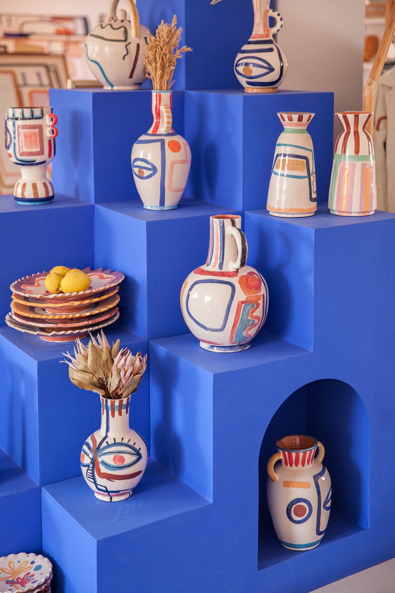 majorette blue shelf with lots of vases