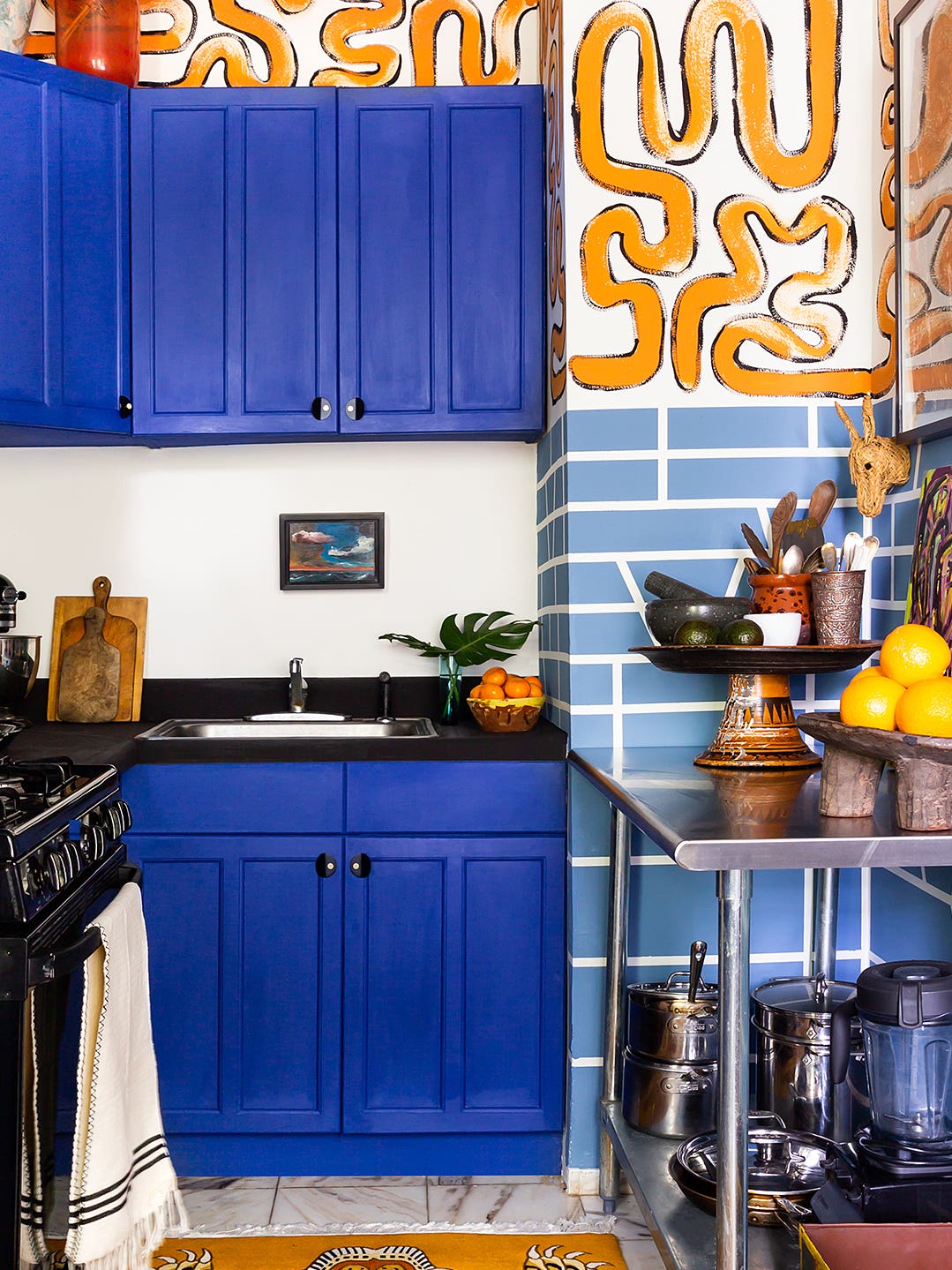 Kitchen with blue cabinets and abstract-painted wall