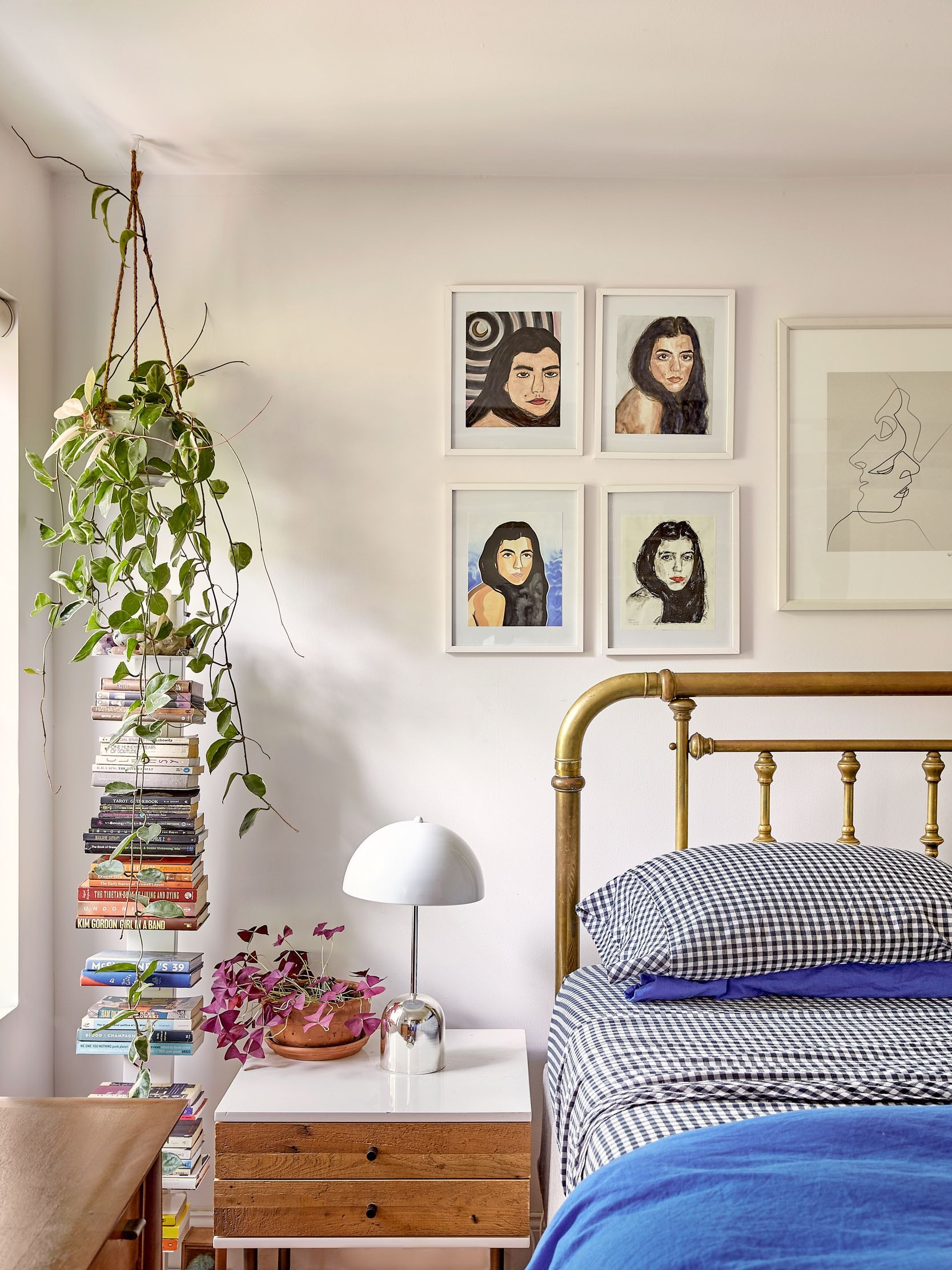 Bedroom with hanging plant and stack of books