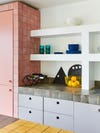 kitchen corner with white shelving and pink cabinet